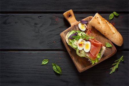 Fresh egg ham sandwich on dark board. Photographie de stock - Aubaine LD & Abonnement, Code: 400-08730041