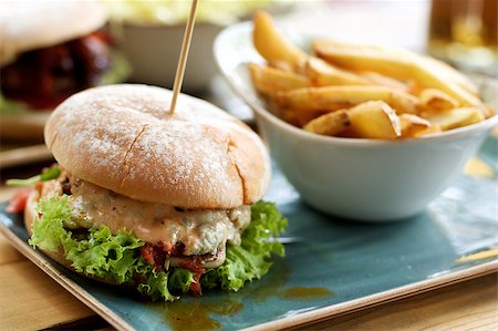 plate of hamburger and fries - Delicious Burger with Chicken, Lettuce, Grilled Tomato and Cheese Sauce and Bowl with French Fries closeup Outdoors. Focus on Foreground Stock Photo - Budget Royalty-Free & Subscription, Code: 400-08730441