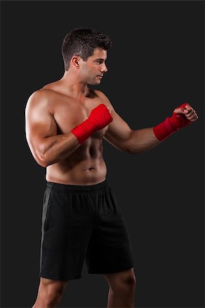 simsearch:400-04222731,k - Portrait of a muscular man practicing body combat against a dark background Photographie de stock - Aubaine LD & Abonnement, Code: 400-08730603