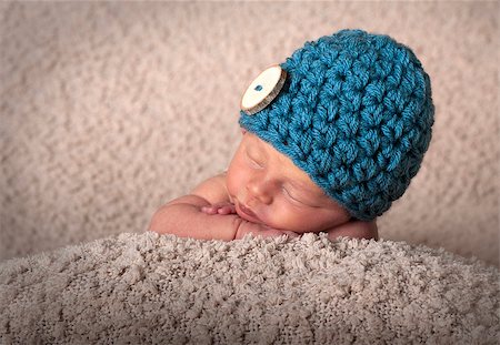 Sleeping tiny newborn Baby wearing a hat Stock Photo - Budget Royalty-Free & Subscription, Code: 400-08730945