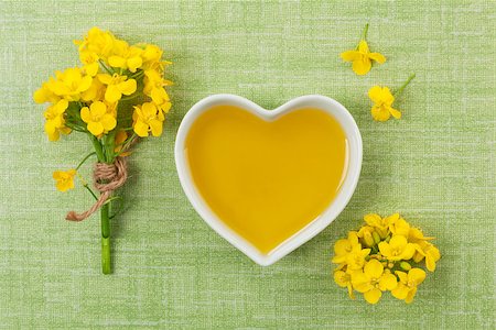 edible oil - Rapeseed oil in heart shaped bowl and flowers on green background, top view. Stock Photo - Budget Royalty-Free & Subscription, Code: 400-08731239