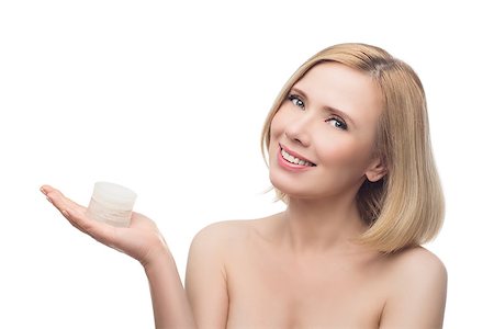 Beautiful middle aged woman with smooth skin and short blond hair holding moisturizing cream. Beauty shot. Isolated over white background. Copy space. Photographie de stock - Aubaine LD & Abonnement, Code: 400-08731484