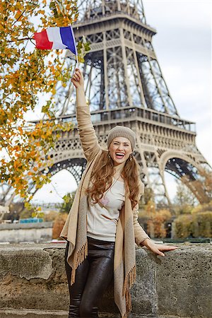 simsearch:400-09031587,k - Autumn getaways in Paris. smiling young tourist woman on embankment in Paris, France rising flag Stock Photo - Budget Royalty-Free & Subscription, Code: 400-08733686