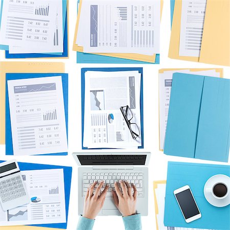 simsearch:400-03910193,k - Business woman working at desktop on a laptop with financial reports, paperwork and files, top view, unrecognizable person Fotografie stock - Microstock e Abbonamento, Codice: 400-08749590