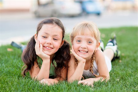 rollerblade girl - Two little girls in roller skates laying on the grass and having fun Stock Photo - Budget Royalty-Free & Subscription, Code: 400-08749778