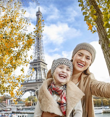 simsearch:400-09031587,k - Autumn getaways in Paris with family. happy mother and child travellers on embankment near Eiffel tower in Paris, France taking selfie while sitting on the parapet Stock Photo - Budget Royalty-Free & Subscription, Code: 400-08749876