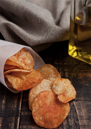 Bowl with potato crisps chips and olive oil on wooden board. Junk food Stock Photo - Budget Royalty-Free & Subscription, Code: 400-08759206