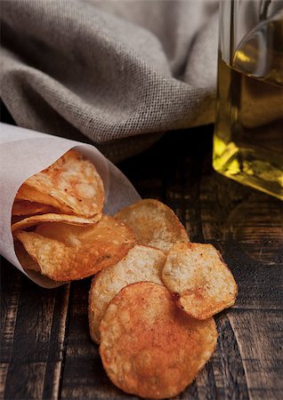 simsearch:400-07994208,k - Bowl with potato crisps chips and olive oil on wooden board. Junk food Photographie de stock - Aubaine LD & Abonnement, Code: 400-08759206