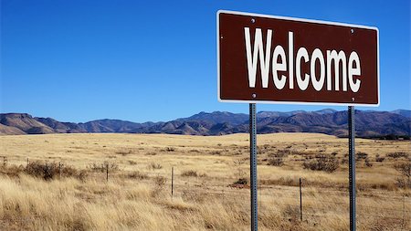 Welcome brown road sign with blue sky and wilderness Stock Photo - Budget Royalty-Free & Subscription, Code: 400-08759242