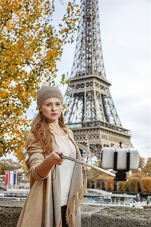 simsearch:400-09031587,k - Autumn getaways in Paris. young elegant woman on embankment near Eiffel tower in Paris, France taking selfie using selfie stick Stock Photo - Budget Royalty-Free & Subscription, Code: 400-08750538