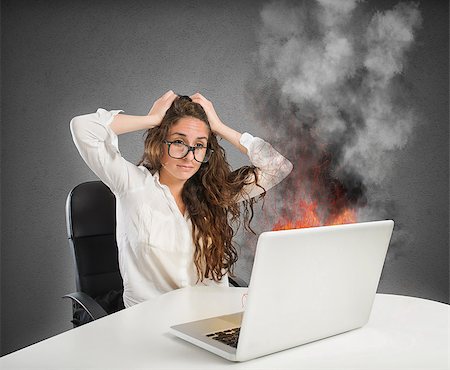 erro - Businesswoman with stressed expression looks at the laptop on fire Foto de stock - Royalty-Free Super Valor e Assinatura, Número: 400-08750882