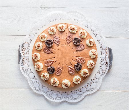 Chocolate cream cake on white wood with cake lace. Stock Photo - Budget Royalty-Free & Subscription, Code: 400-08750900
