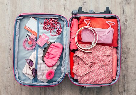 simsearch:400-09222181,k - Woman's open bag on a desktop with clothing and accessories, she is packing and getting ready to leave, travel and vacations concept Fotografie stock - Microstock e Abbonamento, Codice: 400-08751439