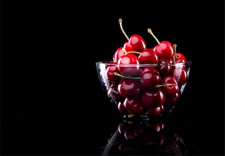 Juicy shiny cherries in a glass bowl on black background. Stock Photo - Budget Royalty-Free & Subscription, Code: 400-08751589