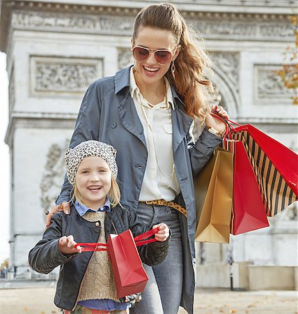 Stylish autumn in Paris. smiling young mother and child with shopping bags near Arc de Triomphe in Paris, France having fun time Foto de stock - Super Valor sin royalties y Suscripción, Código: 400-08751650