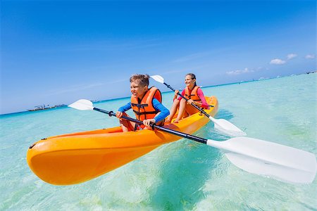 simsearch:400-04607337,k - Kids enjoying paddling in orange kayak at tropical ocean water during summer vacation Stockbilder - Microstock & Abonnement, Bildnummer: 400-08752658