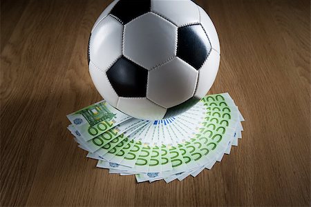 Soccer ball with fan of euro banknotes on hardwood floor. Stock Photo - Budget Royalty-Free & Subscription, Code: 400-08753386