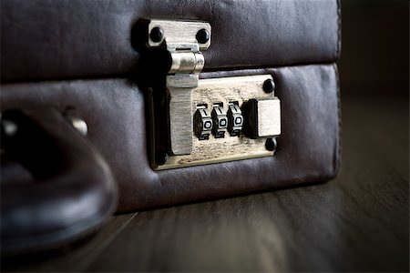 simsearch:649-08564128,k - Leather briefcase lock and handle close-up on dark hardwood floor. Stockbilder - Microstock & Abonnement, Bildnummer: 400-08753413