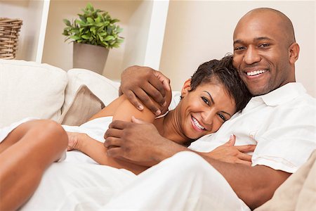 simsearch:400-04655736,k - A happy African American man and woman couple in their thirties sitting at home together smiling. Stockbilder - Microstock & Abonnement, Bildnummer: 400-08775615