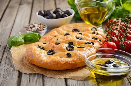 Italian Focaccia bread with olives and rosemary on rustic wooden background, selective focus, copy space Stockbilder - Microstock & Abonnement, Bildnummer: 400-08771256
