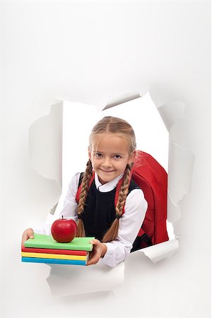 Enthusiastic little schoolgirl ready for school - bursting out from a white paper layer, copy space Photographie de stock - Aubaine LD & Abonnement, Code: 400-08771352