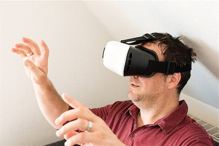 digital experience - Caucasian man resting on comfortable sofa wearing VR headset glasses and making gestures Photographie de stock - Aubaine LD & Abonnement, Code: 400-08771748