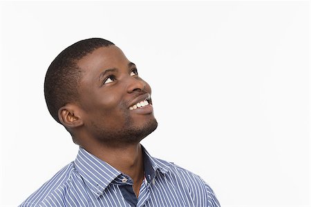 Emotions concept. Portrait of Afro-American man happy smiling and looking upwards while posing isolated on white background in studio. Stock Photo - Budget Royalty-Free & Subscription, Code: 400-08772724