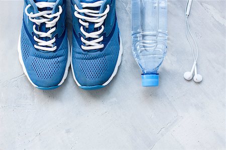 simsearch:400-05144946,k - Flat lay sport shoes, bottle of water and earphones on gray concrete background. Concept healthy lifestyle, sport and diet. Focus is only on the sneakers. Photographie de stock - Aubaine LD & Abonnement, Code: 400-08773970