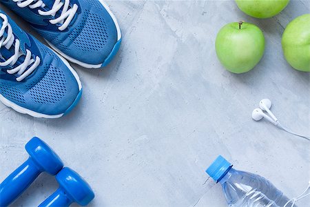 simsearch:400-07976328,k - Flat lay sport shoes, dumbbells, earphones, apples, bottle of water on gray concrete background. Concept healthy lifestyle, sport and diet. Selective focus. Flat lay shot of Sport equipment. Foto de stock - Royalty-Free Super Valor e Assinatura, Número: 400-08773971