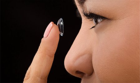 simsearch:6113-07565306,k - Closeup profile of Korean woman putting on contact lenses over black background. Beautiful lady holding contact lens in front of her. Stock Photo - Budget Royalty-Free & Subscription, Code: 400-08785412