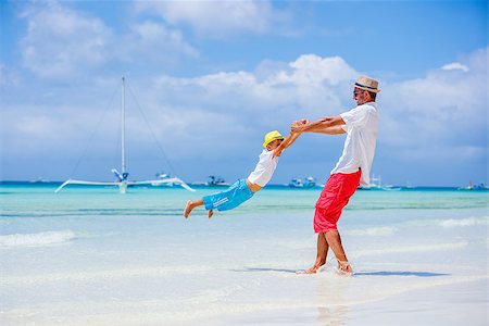 Father and son having fun on tropical white sand beach Stock Photo - Budget Royalty-Free & Subscription, Code: 400-08785883