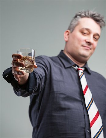 drunk unconscious person - man offering some liquid courage as a solution to your problems or is it simply ice tea on the rocks Stock Photo - Budget Royalty-Free & Subscription, Code: 400-08794341