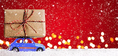 Blue retro toy car delivering Christmas or New Year gifts on festive red background Stock Photo - Budget Royalty-Free & Subscription, Code: 400-08795079