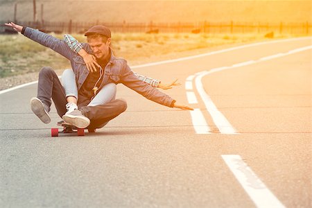 rammellzee (artist) - The guy with the girl drive to longboard on a mountain road. Woman hugging man. Their hands separated in different directions Stock Photo - Budget Royalty-Free & Subscription, Code: 400-08795354