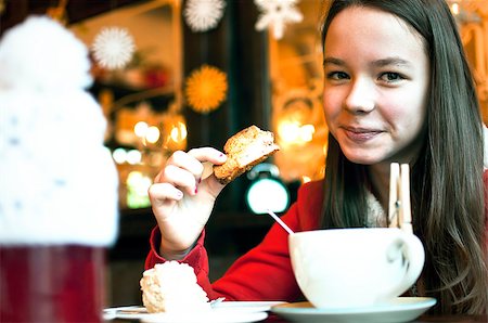 Girl with a cup of tea in a cafe eating Christmas cookies and smile Stockbilder - Microstock & Abonnement, Bildnummer: 400-08795688