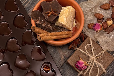 Homemade chocolate candys, cocoa, cocoa butter, nuts, present box, cinnamon and dry roses on wooden background Photographie de stock - Aubaine LD & Abonnement, Code: 400-08790323