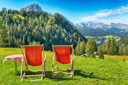 selva gardena - deck chairs and table on the lawn overlooking the mountains and the valley in summer Foto de stock - Royalty-Free Super Valor e Assinatura, Número: 400-08791250
