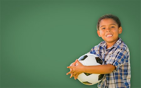 simsearch:400-04125503,k - Cute Smiling Young Mixed Race Boy Holding Soccer Ball In Front of Blank Chalk Board. Photographie de stock - Aubaine LD & Abonnement, Code: 400-08791939