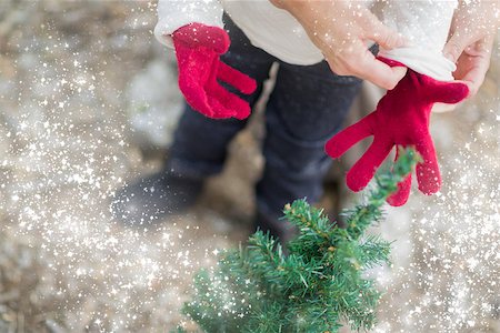 pictures of babies dressed for christmas - Caring Mother Putting Red Mittens On Child Near Small Christmas Tree Abstract with Snow Effect. Stock Photo - Budget Royalty-Free & Subscription, Code: 400-08791949