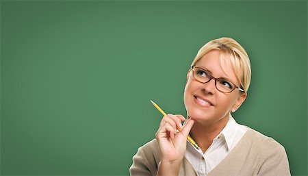 simsearch:400-05127066,k - Attractive Young Woman with Pencil and Glasses In Front of Blank Chalk Board. Photographie de stock - Aubaine LD & Abonnement, Code: 400-08791941