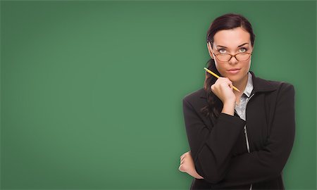 simsearch:400-05127066,k - Serious Young Woman with Pencil and Glasses In Front of Blank Chalk Board. Photographie de stock - Aubaine LD & Abonnement, Code: 400-08791942
