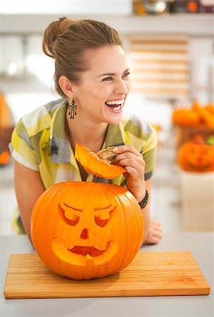 simsearch:400-07172678,k - Frightful Treats on the way. happy modern housewife in the Halloween decorated kitchen with a big orange pumpkin Jack-O-Lantern Photographie de stock - Aubaine LD & Abonnement, Code: 400-08792506