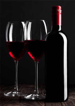 simsearch:400-08793273,k - Red wine bottle and glasses on wooden table black background Foto de stock - Super Valor sin royalties y Suscripción, Código: 400-08793274