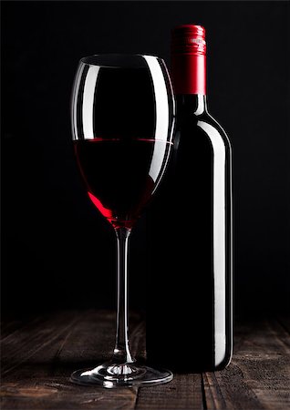 simsearch:400-08793273,k - Red wine bottle and glass on wooden table black background Foto de stock - Super Valor sin royalties y Suscripción, Código: 400-08793275