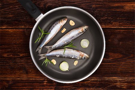 simsearch:400-07776969,k - Fresh anchovy fish on black pan on aged brown textured wooden background. Culinary seafood eating, rustic style. Foto de stock - Super Valor sin royalties y Suscripción, Código: 400-08793664