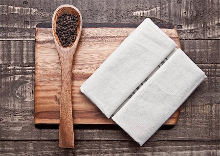 Pepper on spoon and kitchen towel on wooden board. Place for text Photographie de stock - Aubaine LD & Abonnement, Code: 400-08807271