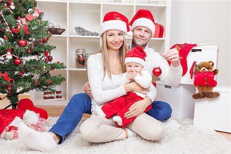 simsearch:400-09222788,k - Happy young family celebrating Christmas at home Photographie de stock - Aubaine LD & Abonnement, Code: 400-08809011