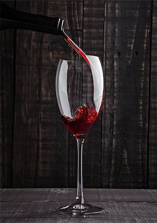 simsearch:400-07829164,k - Pouring red wine into the glass from bottle on old wooden background Stock Photo - Budget Royalty-Free & Subscription, Code: 400-08809600