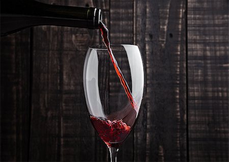 simsearch:400-05676396,k - Pouring red wine into the glass from bottle on old wooden background Stock Photo - Budget Royalty-Free & Subscription, Code: 400-08809601
