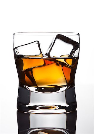 Glasss of whiskey with ice cubes with reflection on white background Stock Photo - Budget Royalty-Free & Subscription, Code: 400-08815452